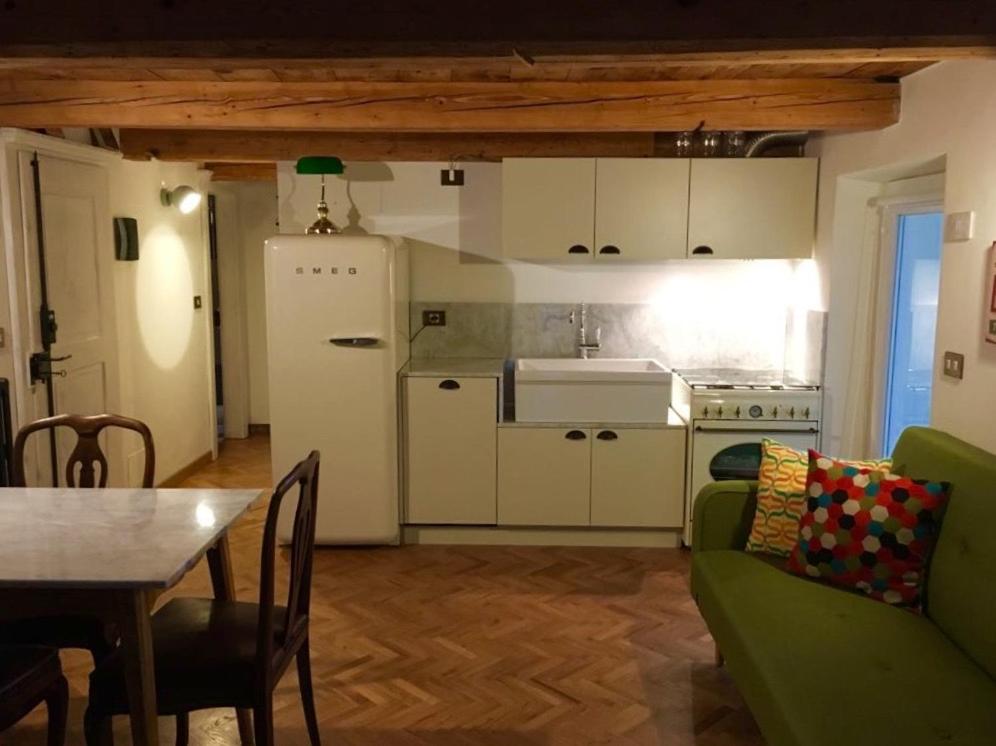 uma sala de estar com um sofá verde e uma cozinha em CASA DELLA NONNA em Croveo