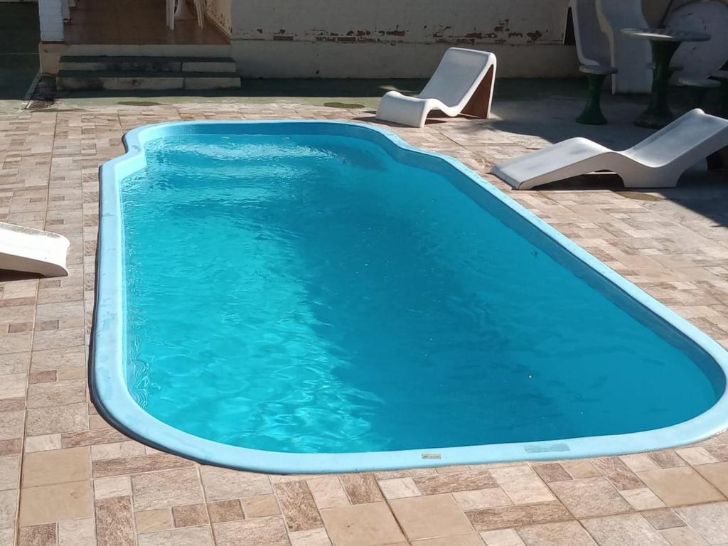 a swimming pool with two chairs and a swimming pool at Casa em Passa Quatro in Passa Quatro