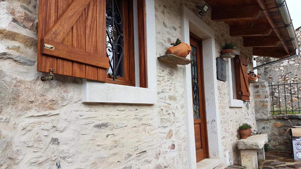 ein Haus mit einer Holztür und einem Fenster in der Unterkunft Casa da Cortiça in Figueiró dos Vinhos