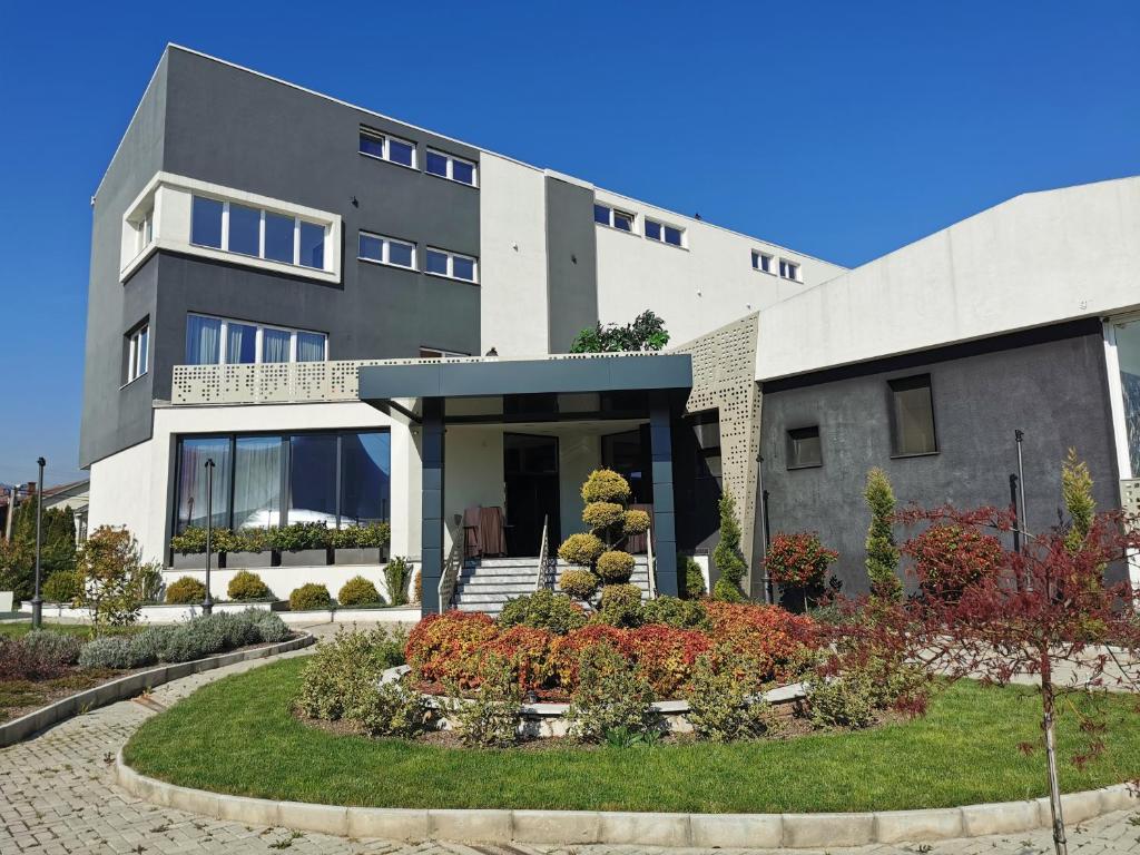 a building with a garden in front of it at Guest rooms Denicija in Skopje