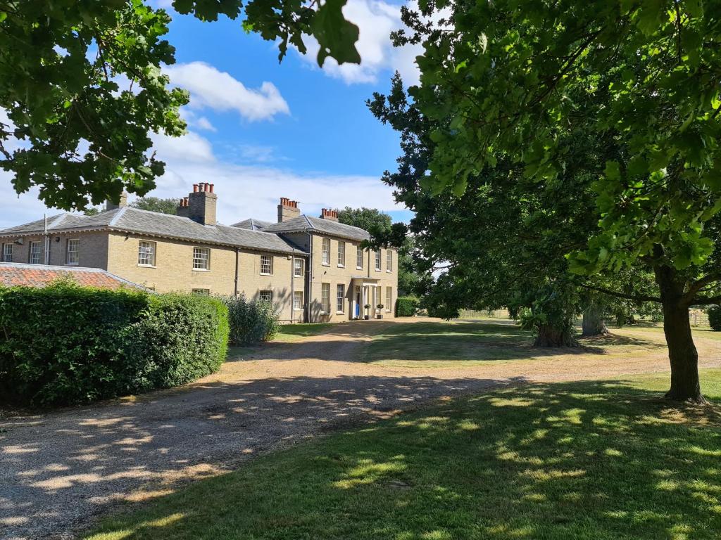 an old house with a tree in front of it at Sloley Hall in Tunstead