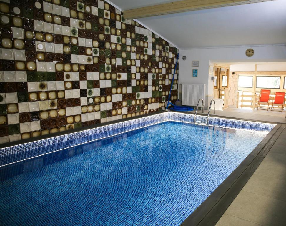 a large swimming pool with a tile wall at NIECH TO SZLAK B&B in Wisła