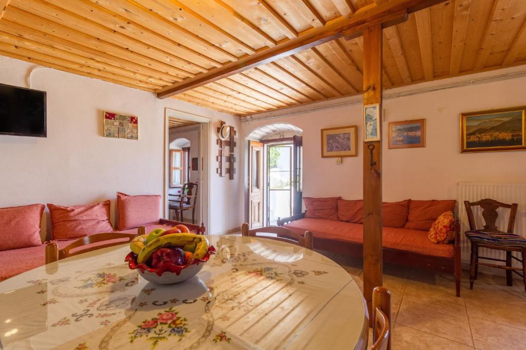 a living room with a table and a couch at The Old House - Wood & Stone in Evretí