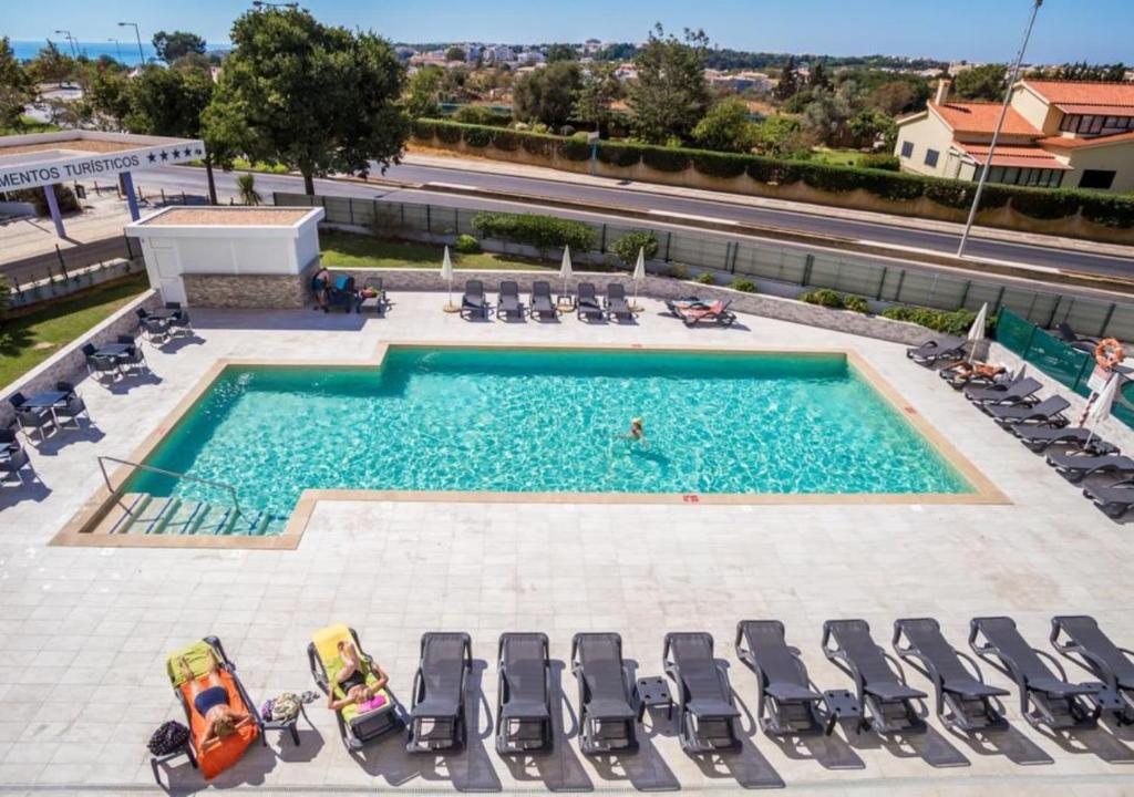 - une vue sur la piscine et ses chaises longues dans l'établissement Praia da Rocha Apartments, à Portimão