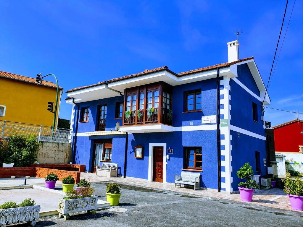 a blue and white house with plants in front of it at Albergue Piedad in Boó de Piélagos