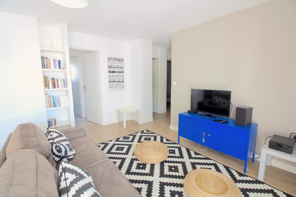 a living room with a couch and a tv at Mon Appart A GERLAND IV in Lyon