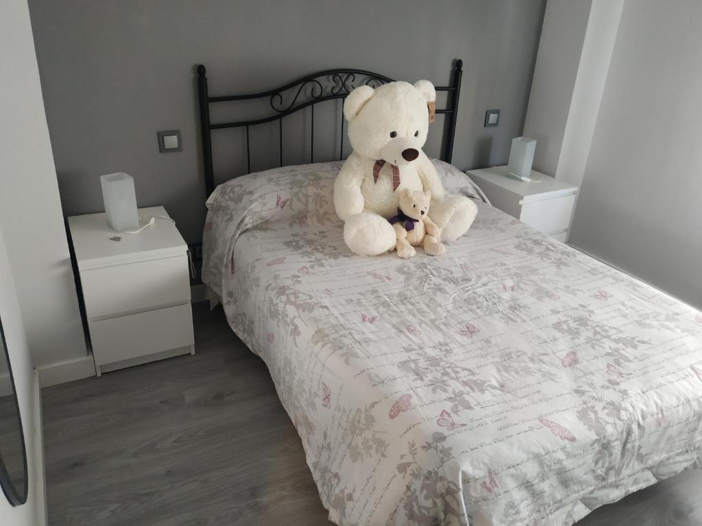 un ours en peluche assis au-dessus d'un lit dans l'établissement Los 3 arboles, à Zamora