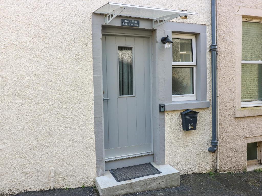 a white door on the side of a building at Beech Tent Lane Cottage in Kelso