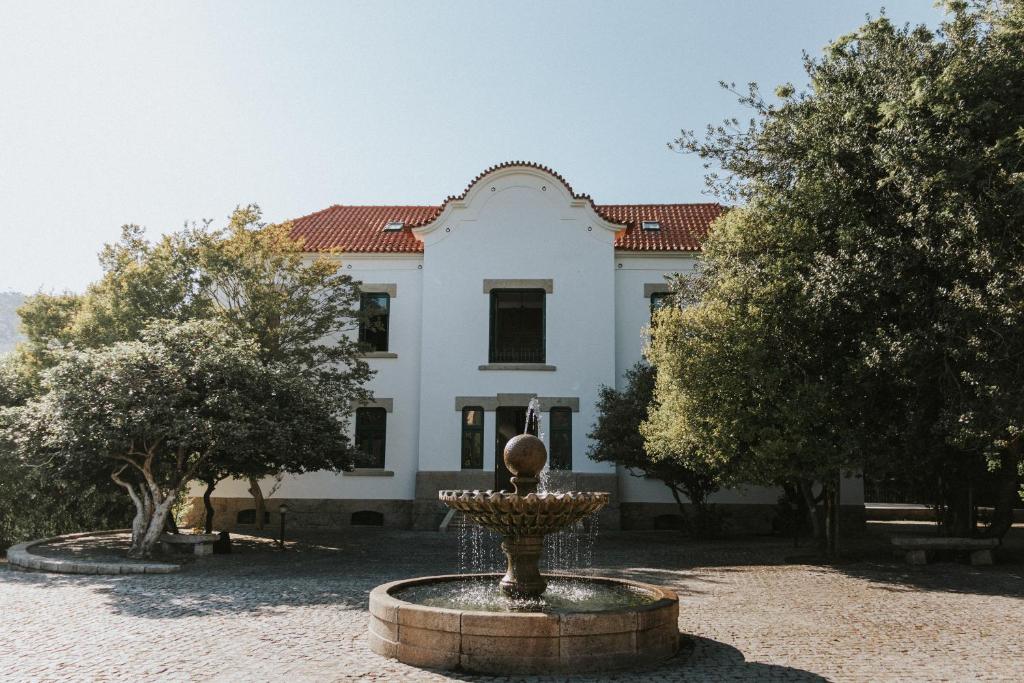 un edificio con una fuente frente a él en Casa dos Vales - Luxury Villa en Penafiel