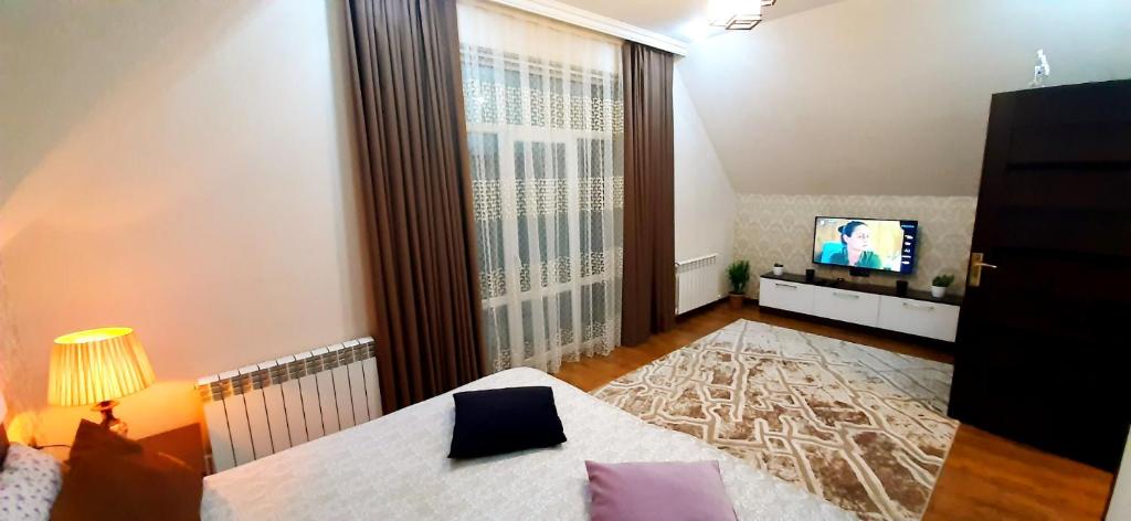 a living room with a large window and a television at Dom Semya Deluxe Gusar in Qusar