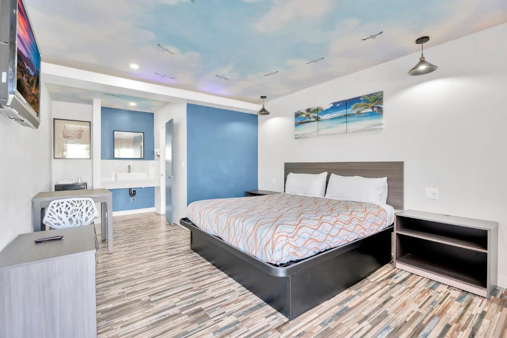 a hotel room with a bed and a tv at Tradewinds Motel in Lakewood