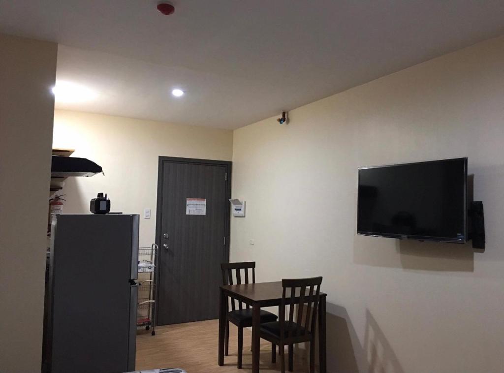 カガヤン・デ・オロにあるBria Flats/Codoのテーブルと壁掛けテレビ付きの部屋