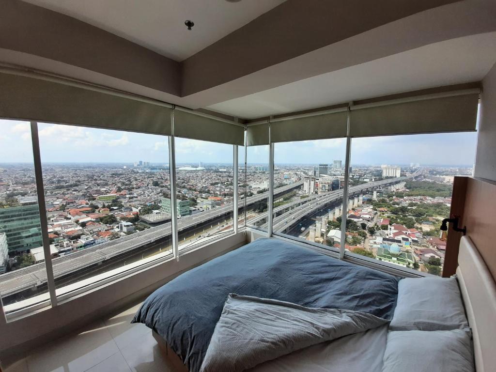 a bed in a room with a large window at Panoramic View Grand Kamala Lagoon in Bekasi