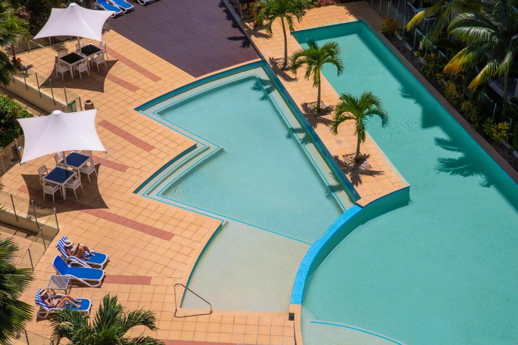 una vista aérea de una piscina con sillas y palmeras en Mantra Trilogy en Cairns