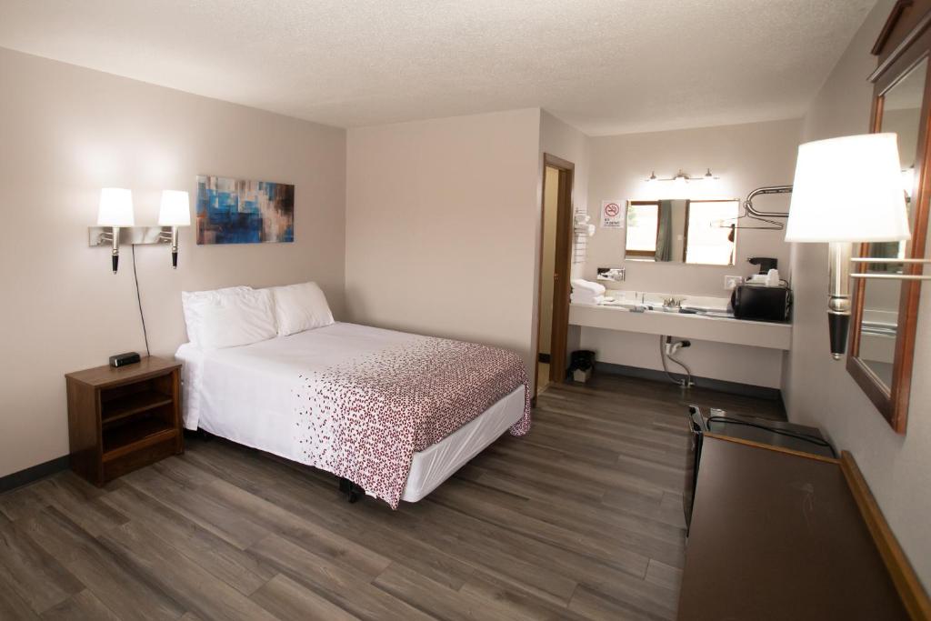 ein Hotelzimmer mit einem Bett und einem Waschbecken in der Unterkunft Shady Rest Motel in Arapahoe