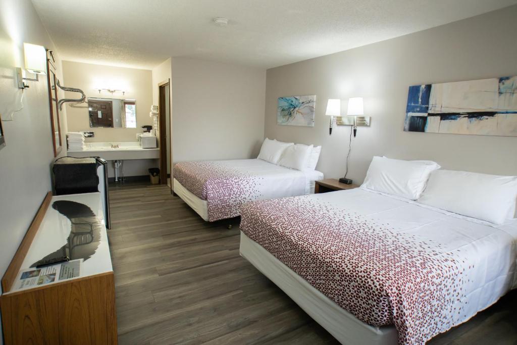 ArapahoeにあるShady Rest Motelのベッド2台とシンク付きのホテルルームです。