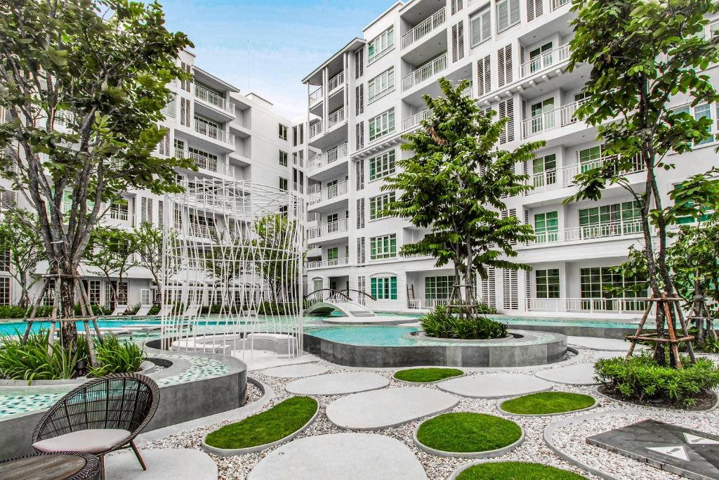an apartment complex with a courtyard with a pool at Summer Hua Hin by Favstay in Hua Hin