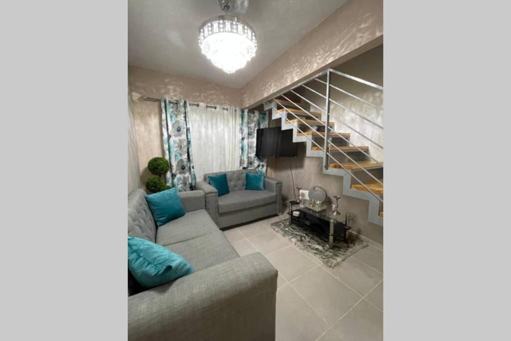 a living room with a couch and a staircase at Penthouse with private rooftop near the airport. in La Javilla