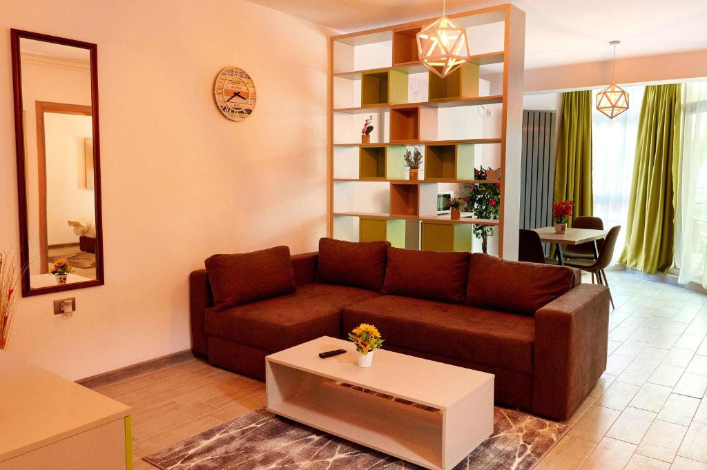 een woonkamer met een bruine bank en een tafel bij Orizont sea view Apartment- Spa n Pools beach resort in Mamaia