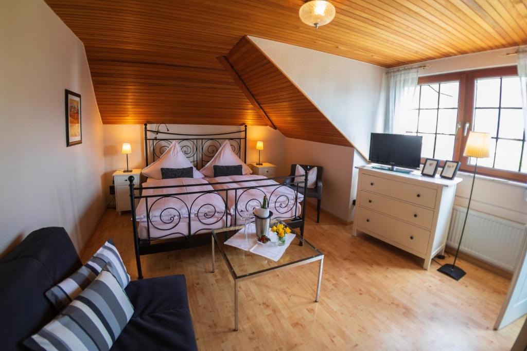 クレフにあるGästehaus Heidiのベッド、ソファ、テレビが備わる客室です。