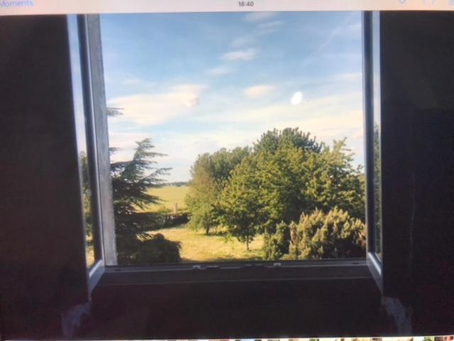 a window with a view of a field and trees at Mazmoura in Reignac-sur-Indre
