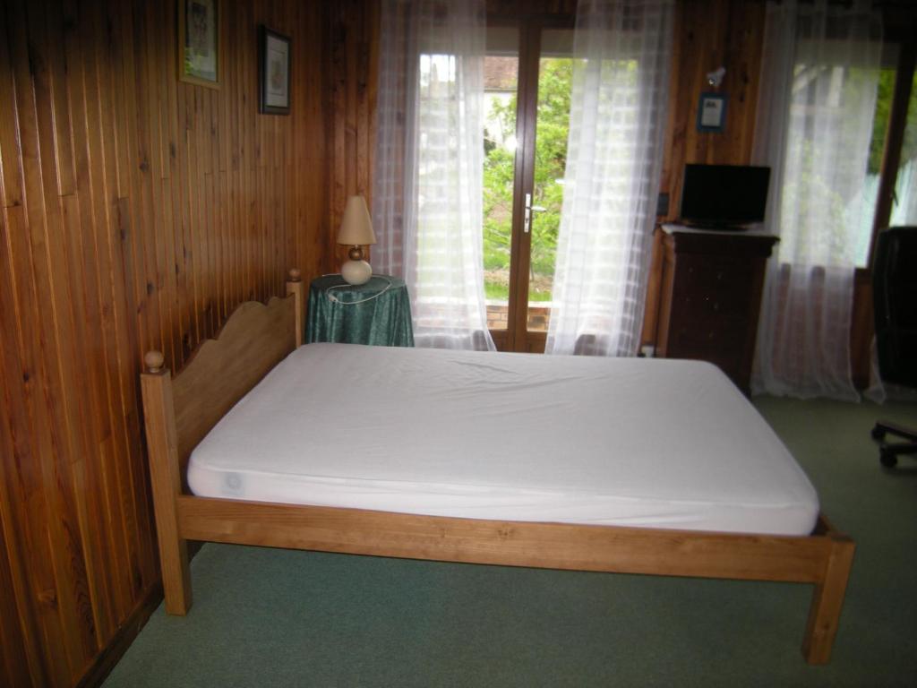 a bed with a white mattress in a room at le clermontain in Les Clérimois