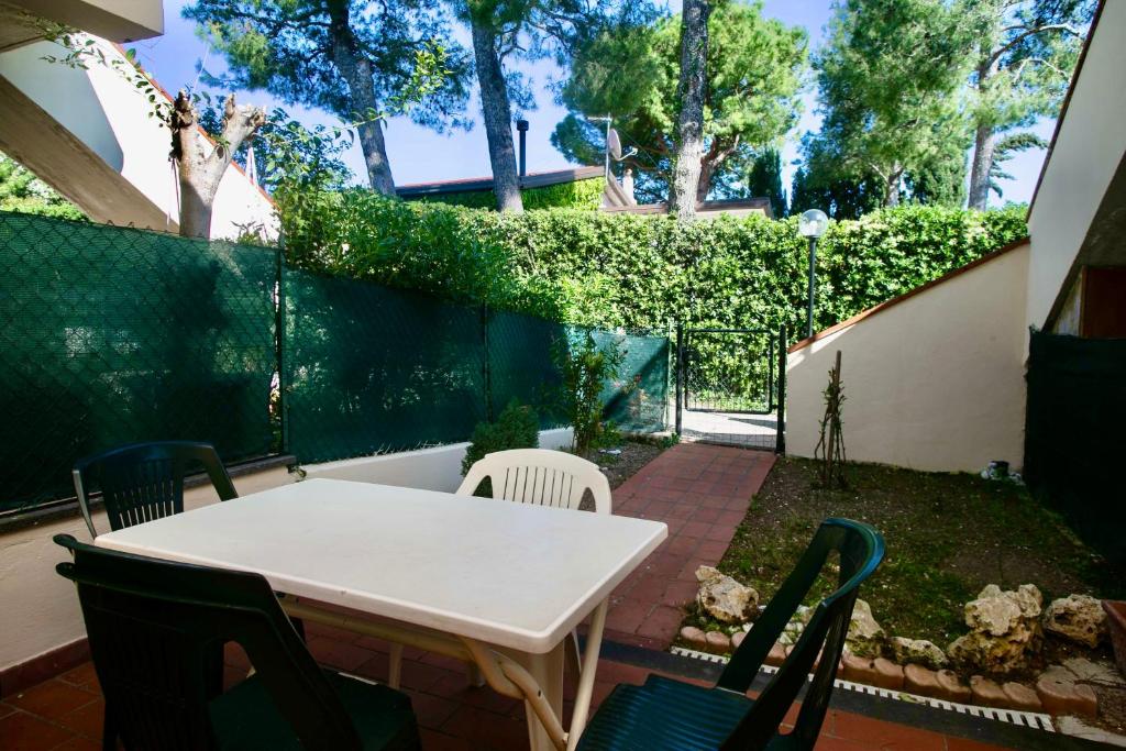 un patio con tavolo e sedie bianchi di N142 - Numana, deliziosa villetta con giardino a Numana