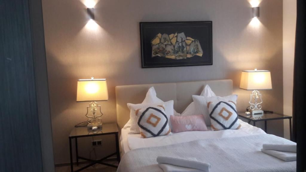 una camera da letto con un letto bianco con cuscini e 2 lampade di Silver Mountain G1 39 Perfect For You a Poiana Brasov