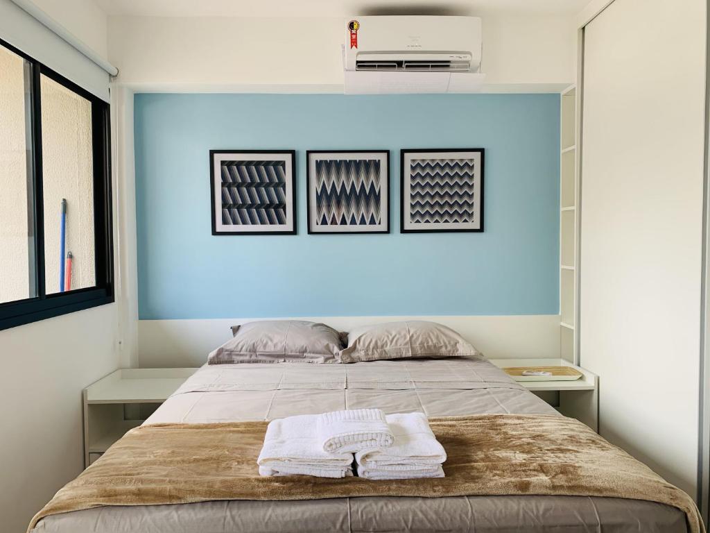 a bedroom with a bed with a blue wall at Akile Movva in São Paulo