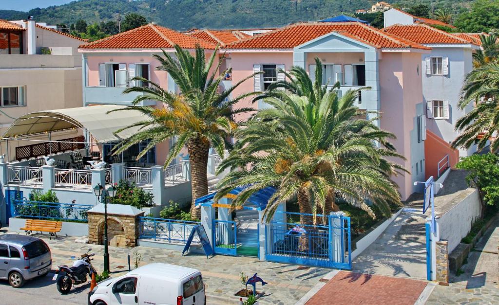 a group of palm trees in front of a building at Dolphin Hotel in Skopelos Town