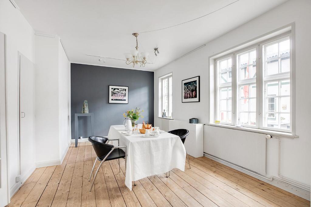 a dining room with a white table and chairs at Korinth Bed & Breakfast in Faaborg