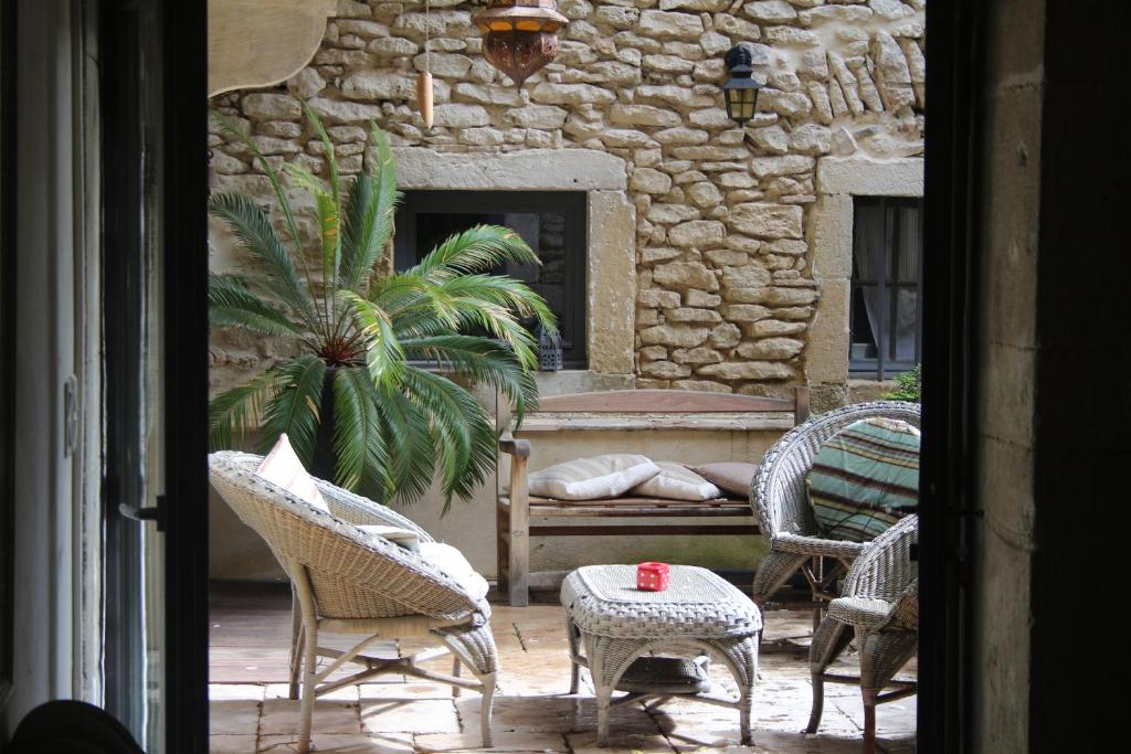 un patio con sillas, una mesa y un banco en LE PATIO, en Grignan