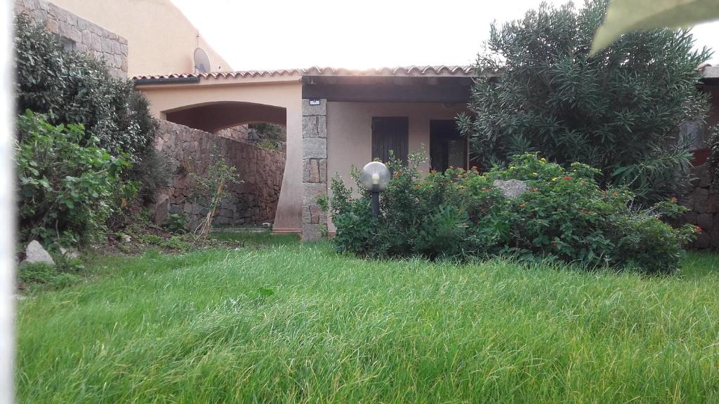 una casa con un cortile con erba alta di Villetta Reparata a Santa Teresa di Gallura