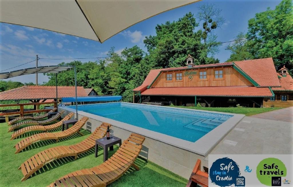 uma piscina com cadeiras e uma casa em Green Paradise em Donje Gredice