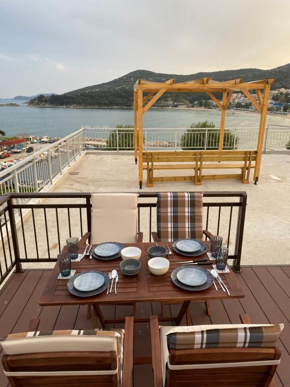 a wooden table on a deck with a view of the water at Overwave Apartment in Kavála