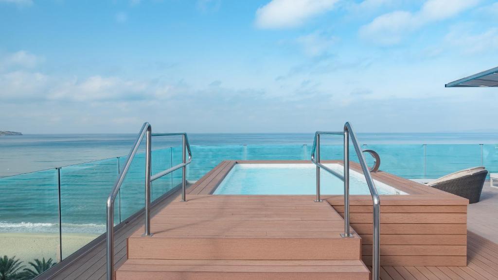 a staircase leading to a swimming pool next to the ocean at Hotel Negresco - Adults Only in Playa de Palma