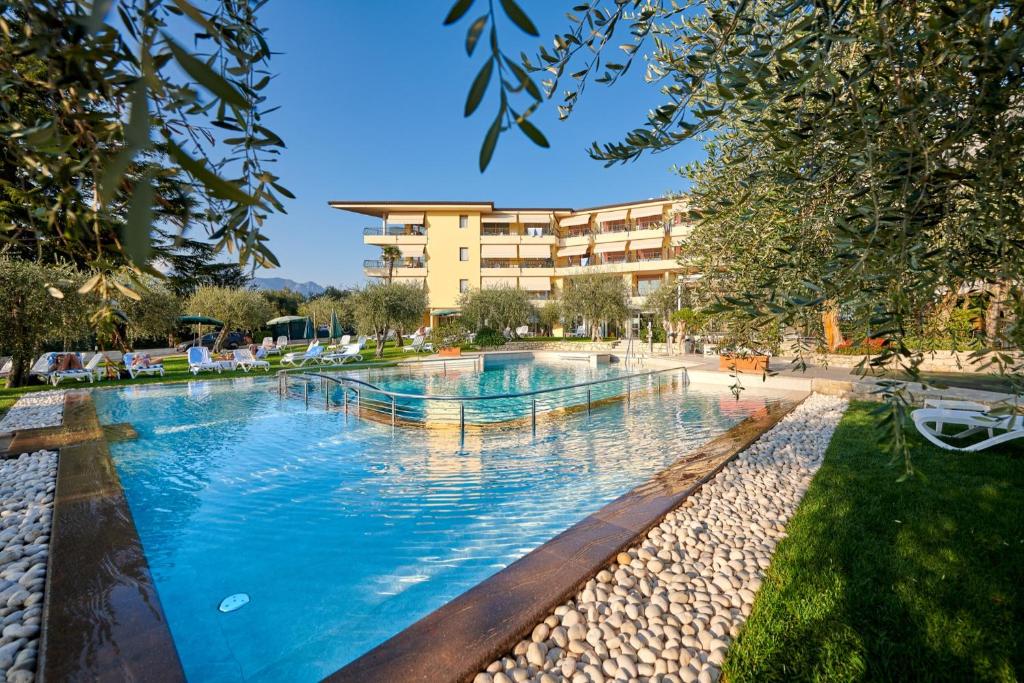 a large swimming pool in front of a building at Hotel Baia Verde in Malcesine