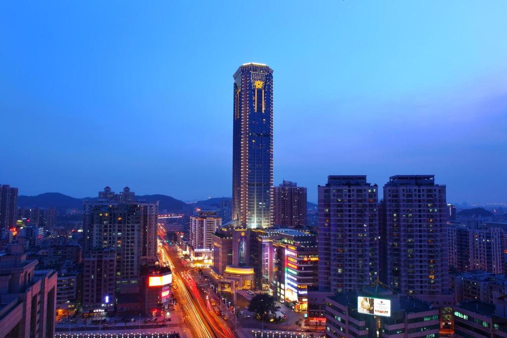 eine Skyline der Stadt in der Nacht mit einem hohen Gebäude in der Unterkunft Mels Weldon Dongguan Humen in Dongguan