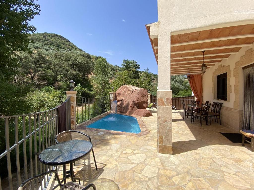 un patio con piscina, mesa y sillas en 5 bedrooms house with private pool furnished terrace and wifi at Zambra en Zambra