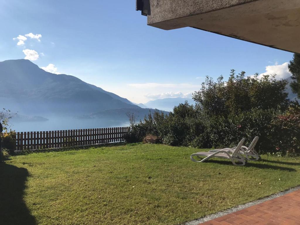 un banco en un patio con montañas al fondo en Casa Maiù, en Vercana