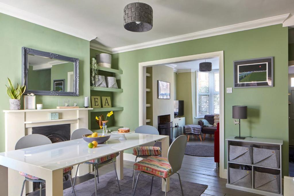 a living room with green walls and a white table and chairs at The Deal Abode - luxury self catering retreat in Deal