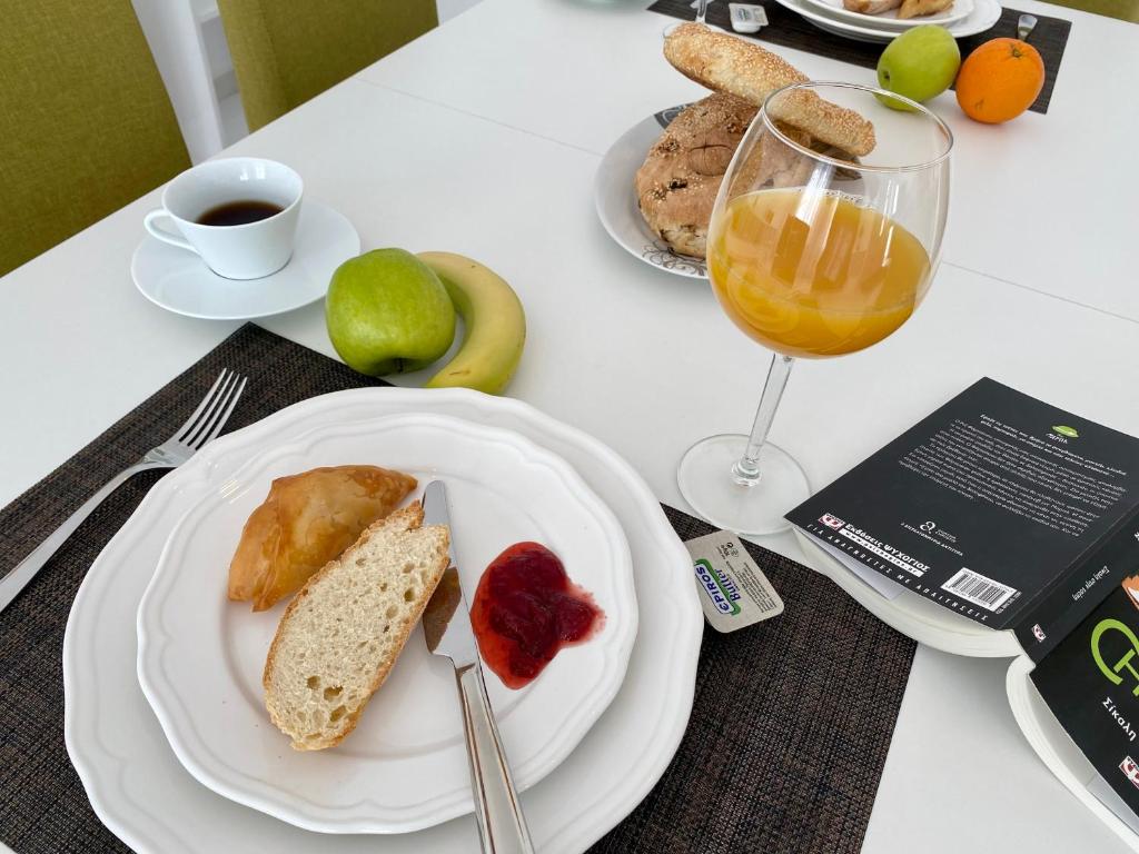 a table with plates of food and a glass of orange juice at PORTA HOME modern and hospitable in Naxos Chora