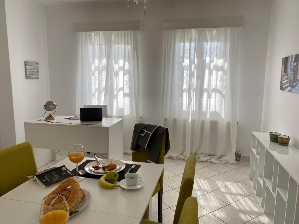 a white room with a table with a plate of food at PORTA HOME modern and hospitable in Naxos Chora
