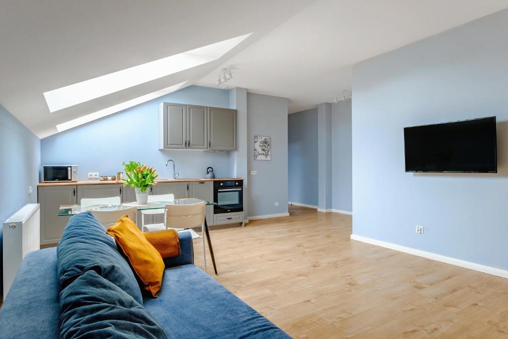 ルブリンにあるApartament w centrum, zarezerwuj terazの青いソファとキッチンのあるリビングルーム