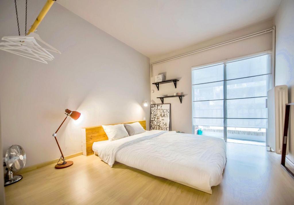 a bedroom with a white bed and a large window at #Pretty Riki Apt by halu! Apartments in Thessaloniki