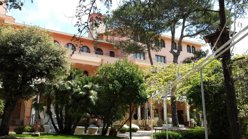 マルティナ・フランカにあるパーク ホテル サン ミケーレの目の前に木々が生い茂るオレンジ色の建物