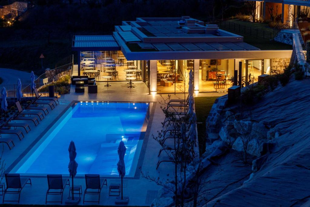 a swimming pool in front of a building at night at Deville & Spa in Costermano