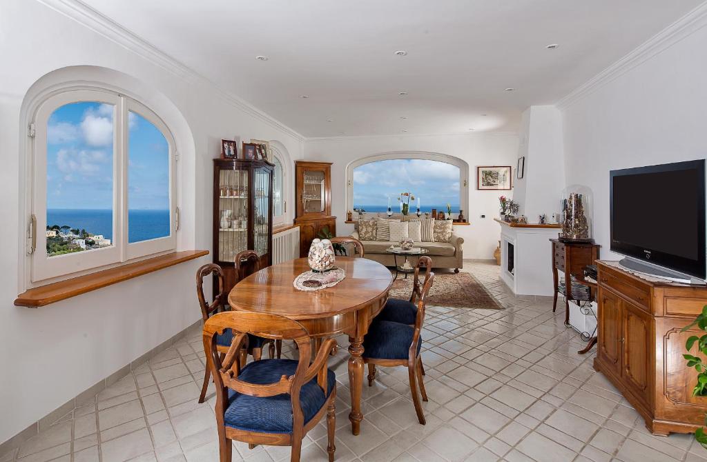 a kitchen and living room with a table and chairs at Aldarogi in Capri