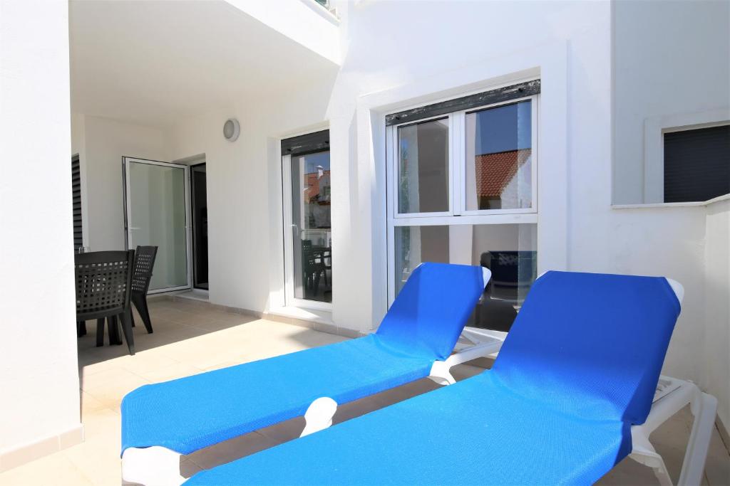 Pokój z 2 niebieskimi krzesłami i salonem w obiekcie Apartment BEATRIX w mieście Estepona