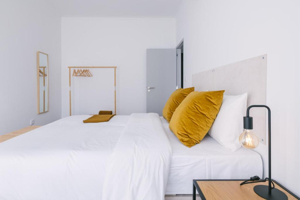ポルトにあるD&S - Family Apartments Iの白いベッドルーム(大きな白いベッド、黄色い枕付)